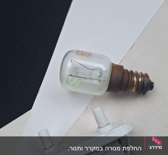 נורה ומתג לבן על רקע נייר